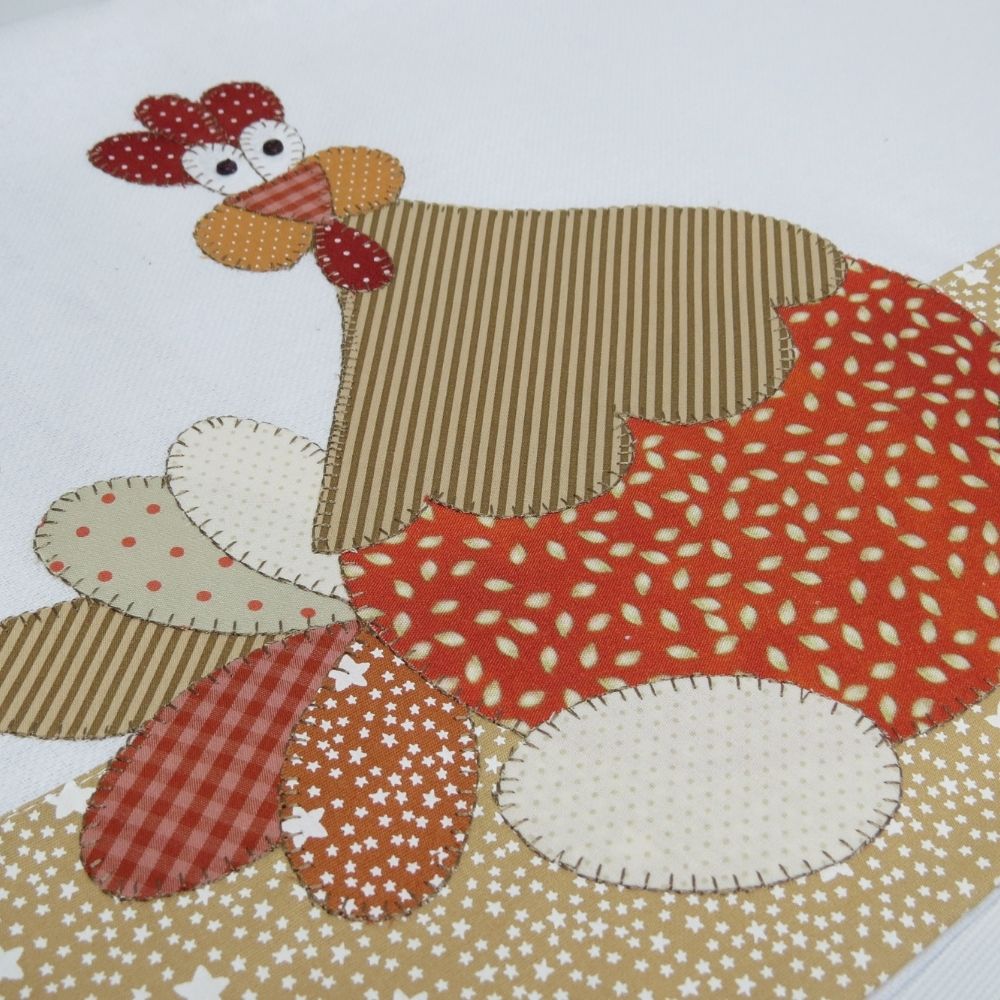 Pano de copa em patch aplique com bordado em ponto caseado. Tema galinha e dois ovos.
